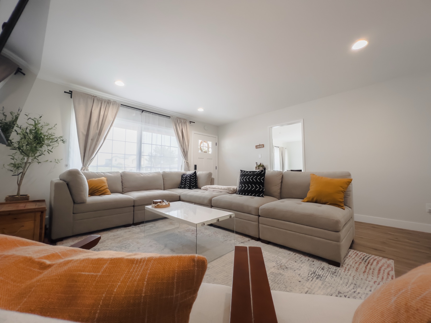 A bright, welcoming shared living room with comfortable sofas and natural light
